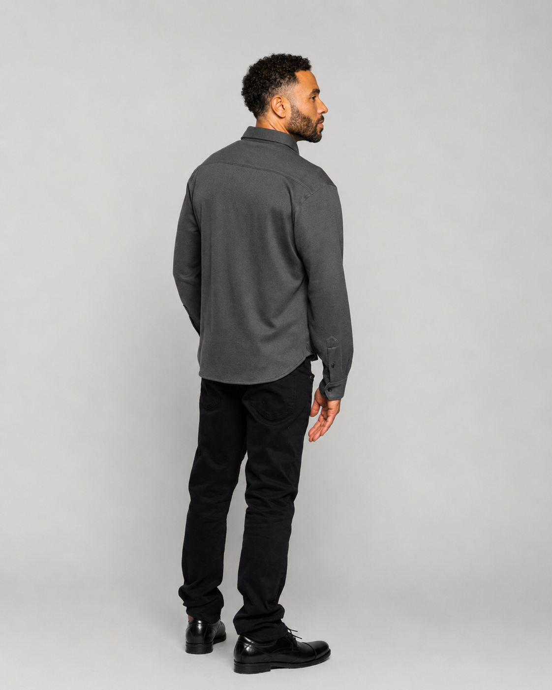 Long-sleeve button-up shirt in dark charcoal, side profile with full-length sleeves