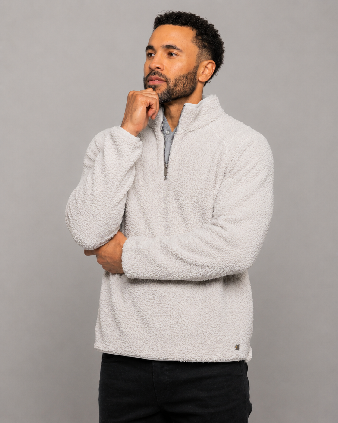 Light gray quarter-zip fleece pullover with stand collar, hand at neck, front view.