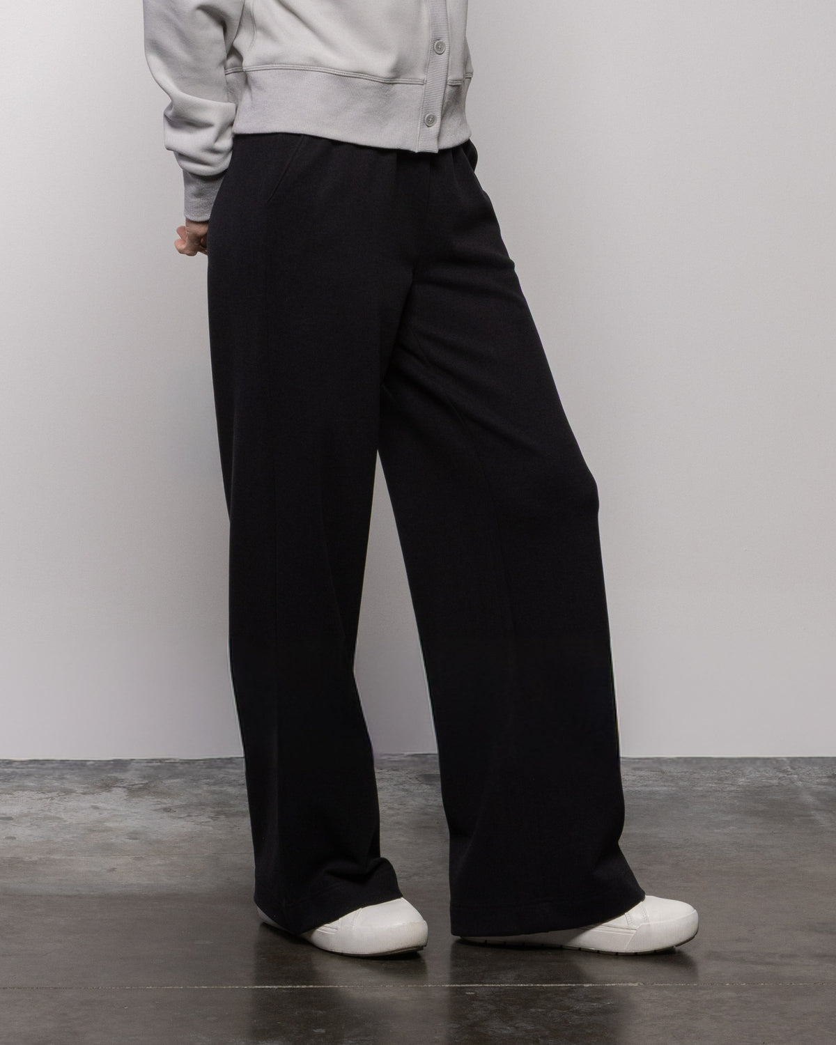 Jet black wide-leg pants with relaxed straight fit, visible pockets and belt loops