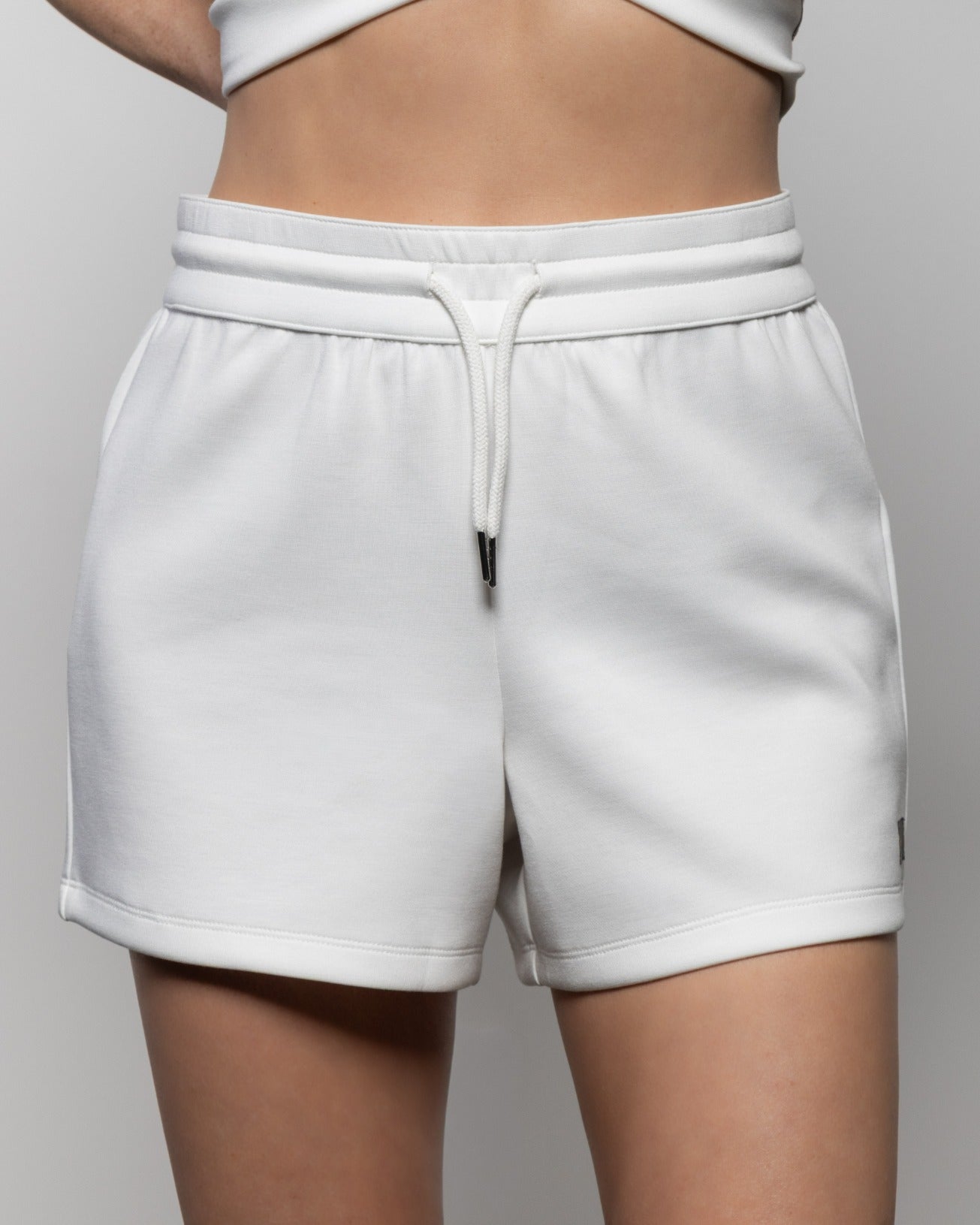 White drawstring shorts with elastic waistband and side pockets