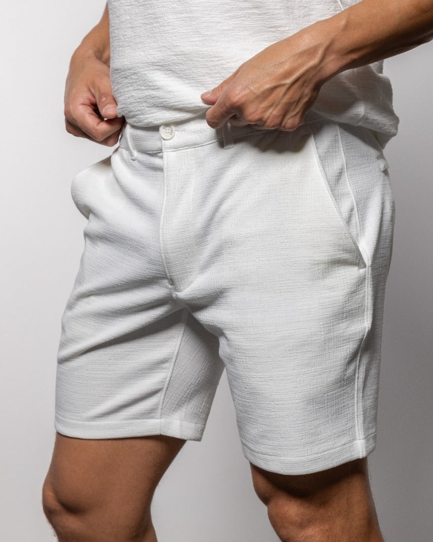 White shorts with button front and side pockets, waistband close-up