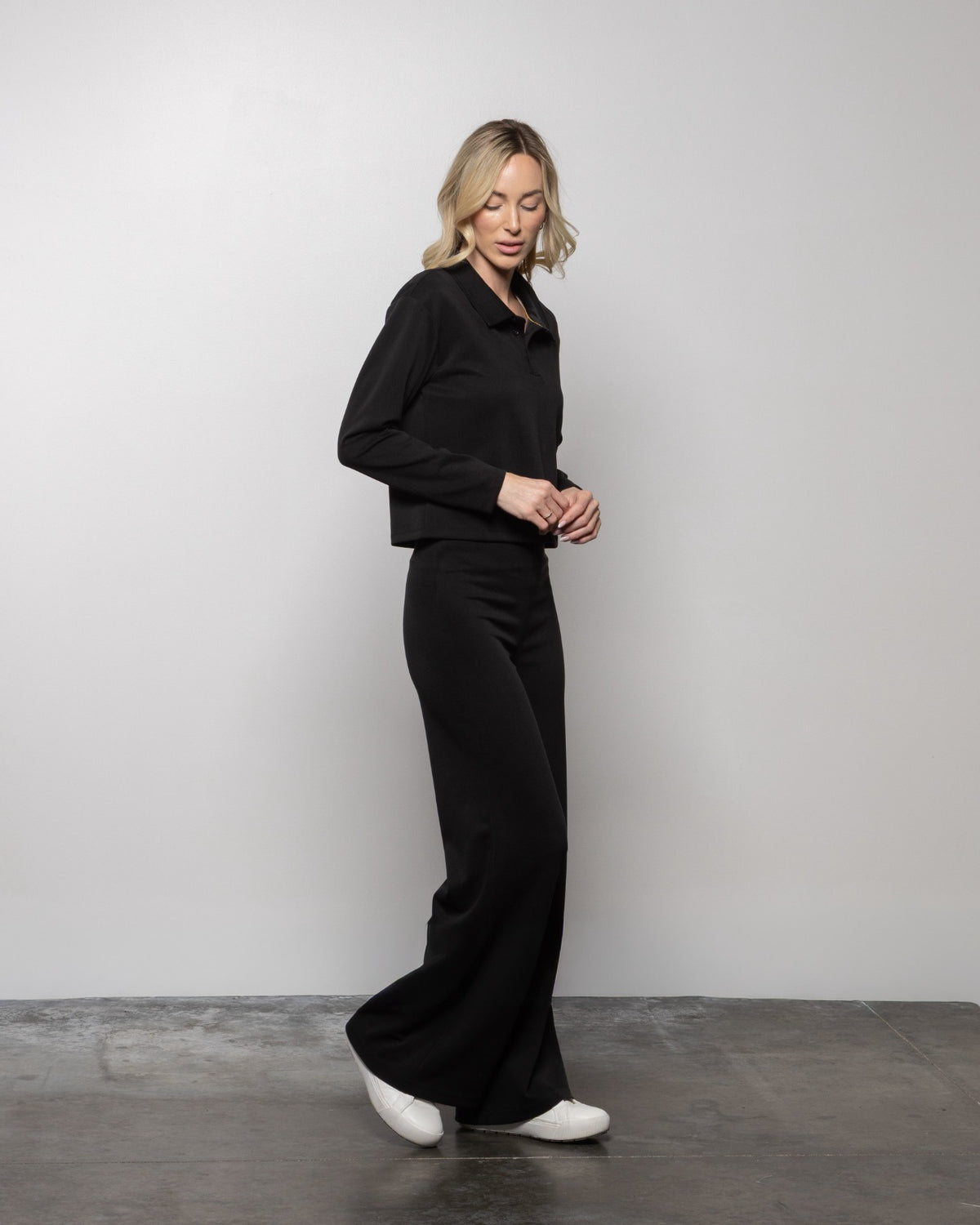 Matte black wide-leg pants with high waist and full-length flare