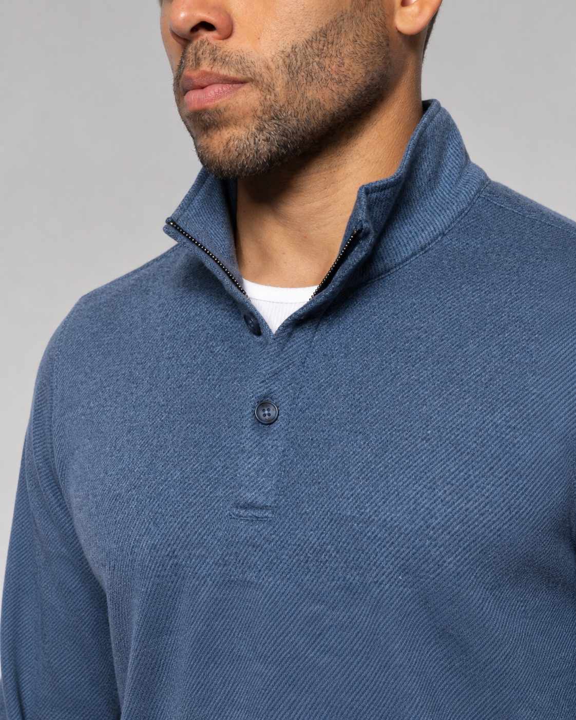 Indigo blue knit mock-neck pullover close-up of collar and button placket