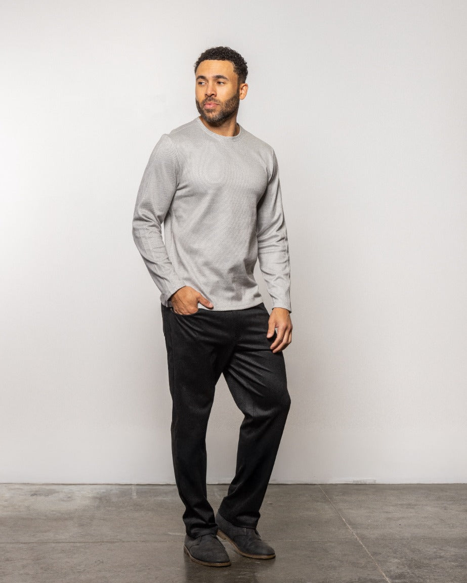 Men's light gray crewneck sweatshirt worn with black pants, full-body view