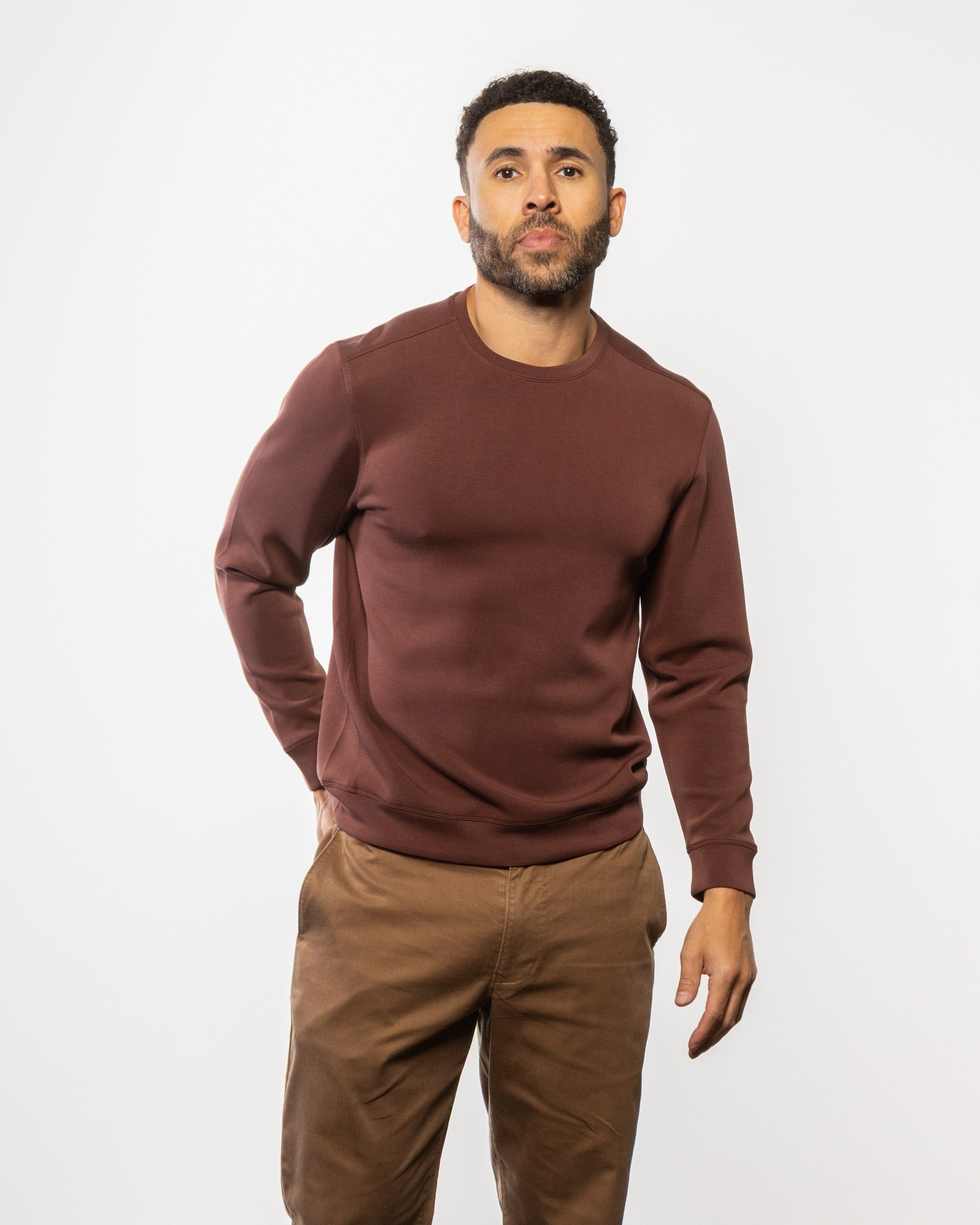Maroon crewneck sweatshirt with long sleeves and ribbed cuffs, worn by model