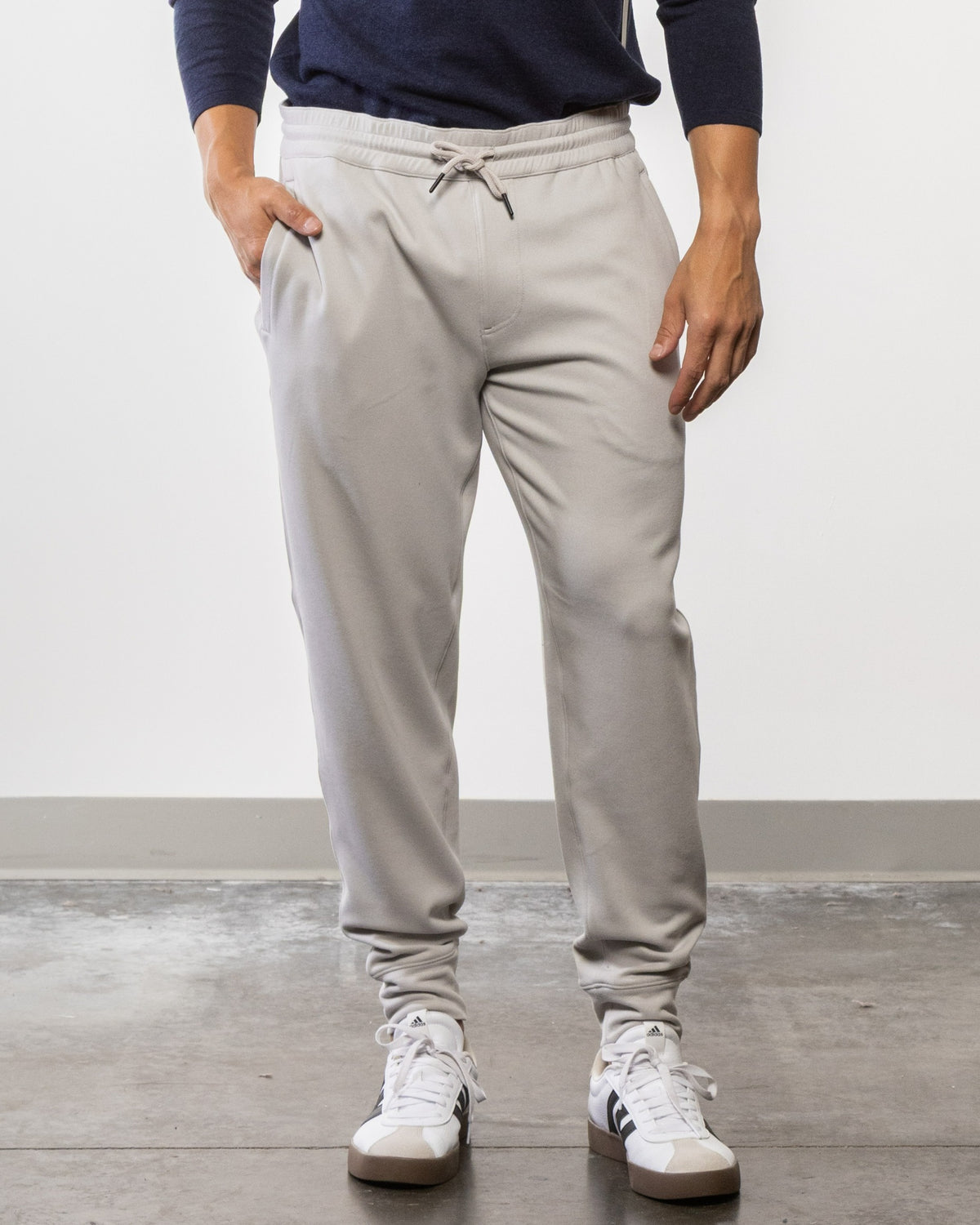 Cement gray jogger pants with drawstring waist, side pockets, and ribbed cuffs