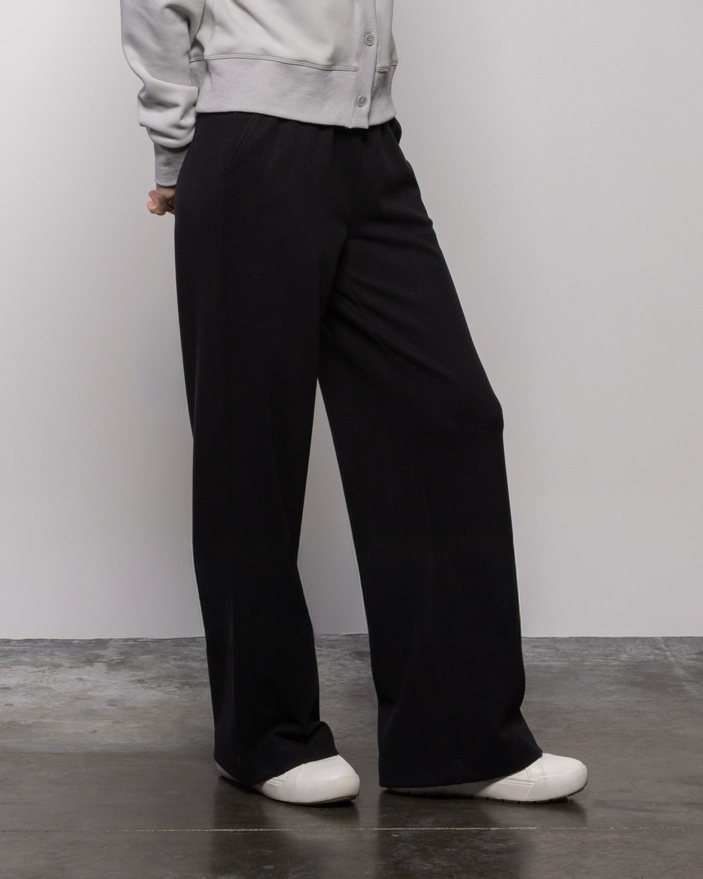 Jet black wide-leg pants with relaxed straight fit, visible pockets and belt loops