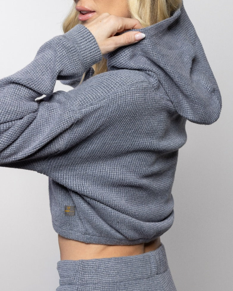 Heather gray-blue hoodie close-up with hood, ribbed cuffs, and drawstring ends