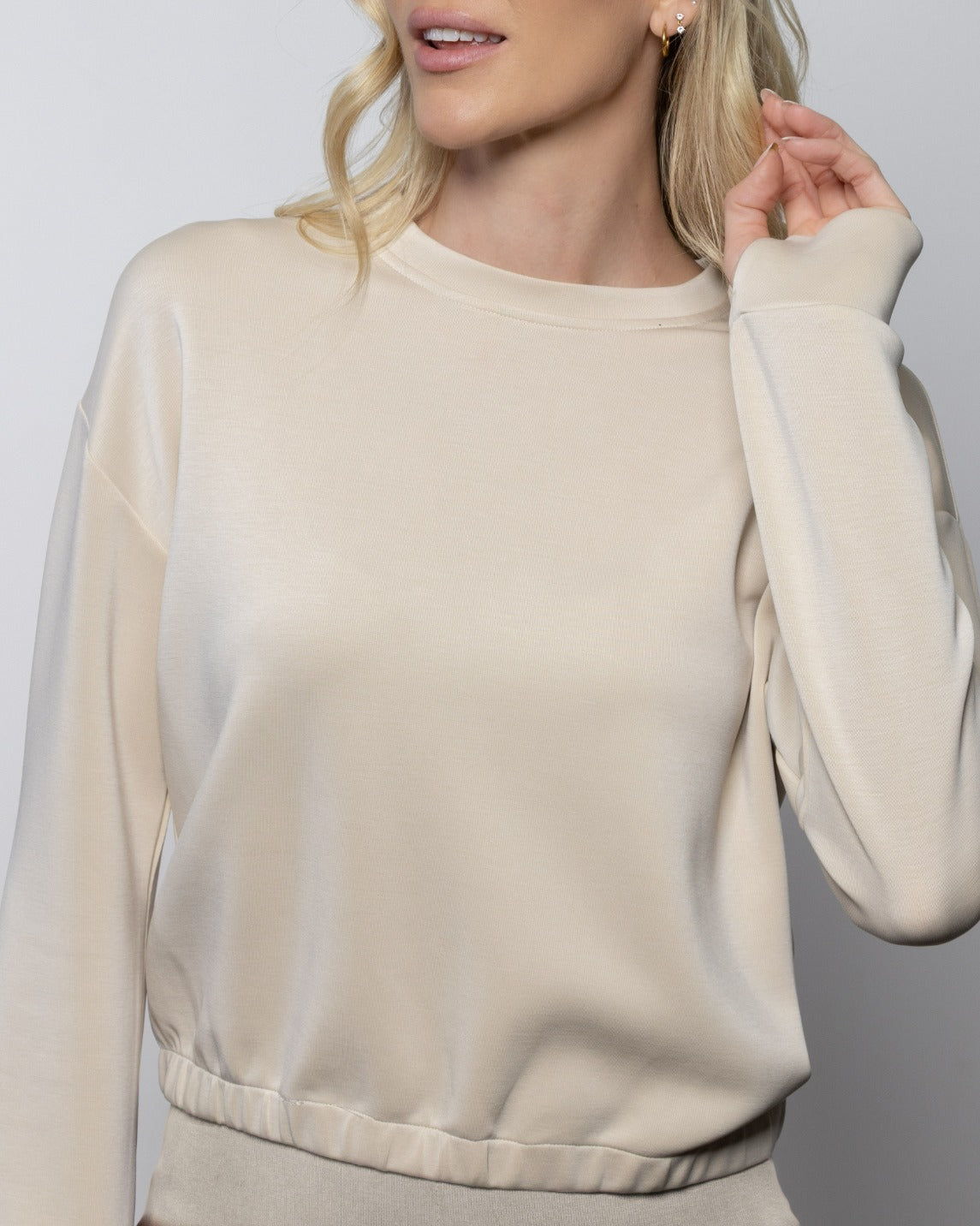 Light beige crewneck sweatshirt with long sleeves and ribbed hem