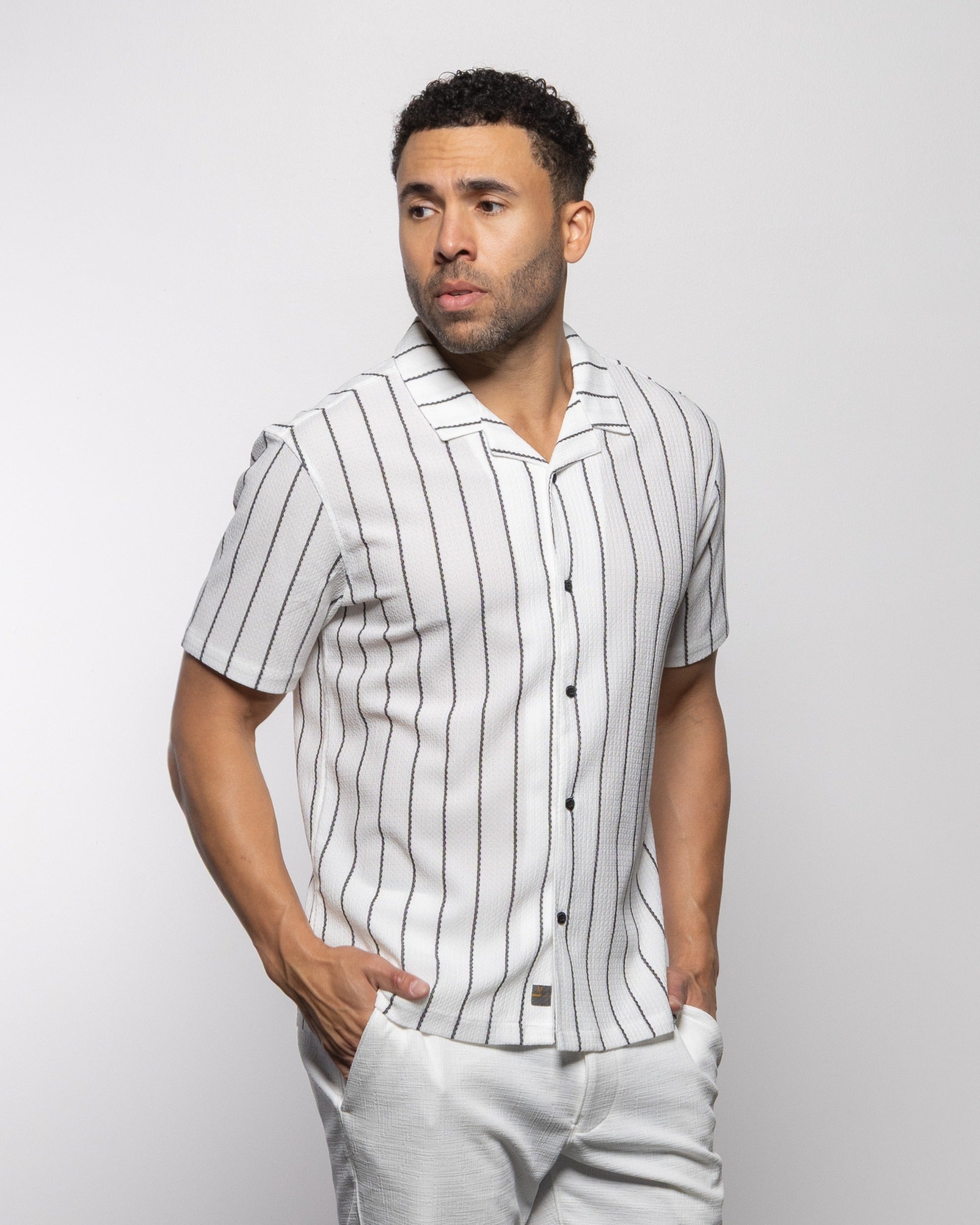 Men's white camp shirt with vertical black stripes, short sleeves, button front