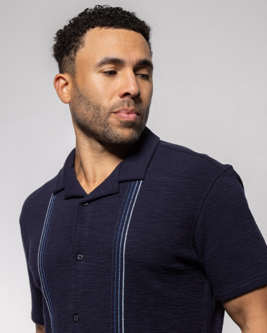 Men's camp shirt close-up: dark indigo night with striped placket and button front