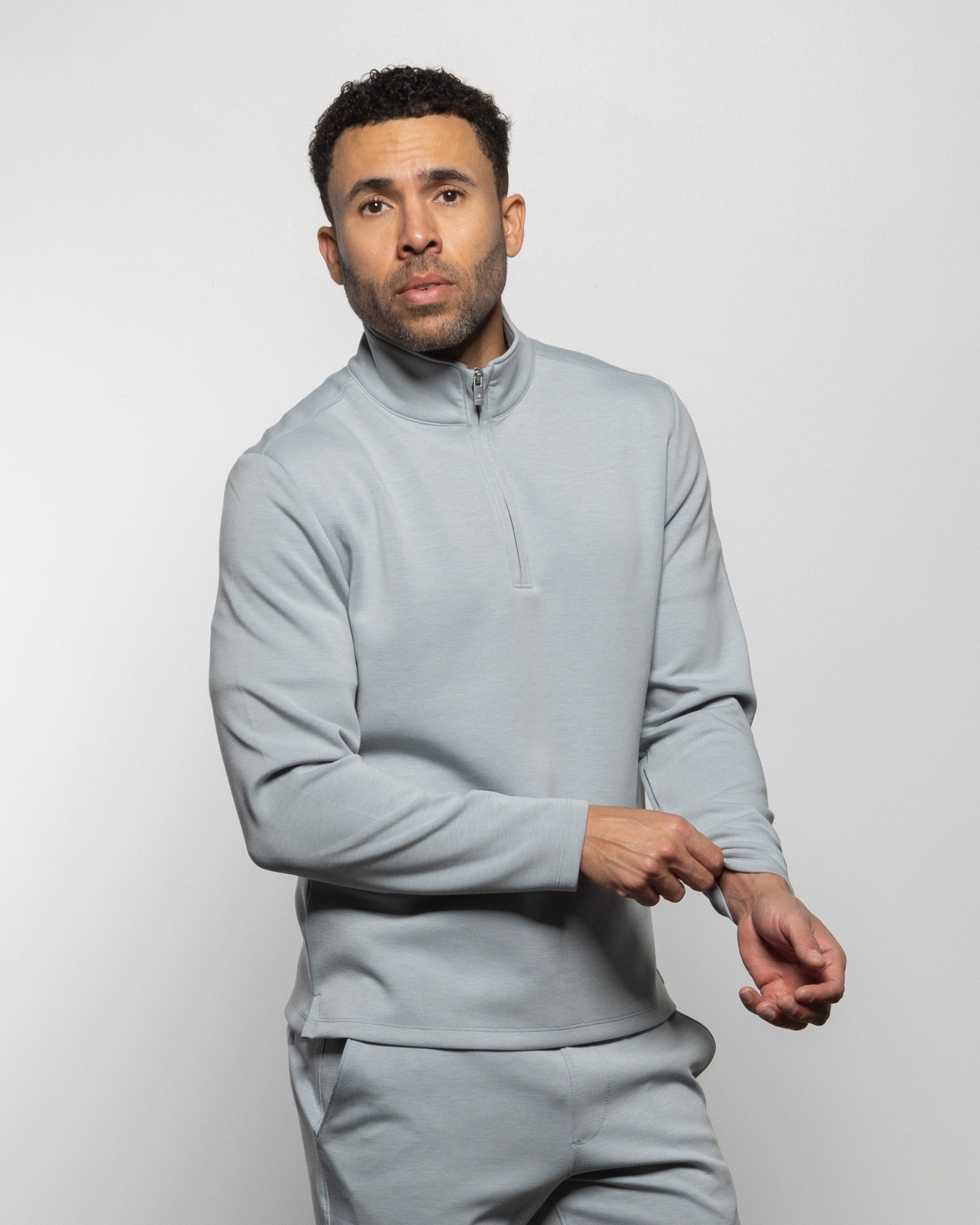 Light gray quarter-zip sweatshirt with short stand collar and pullover fit