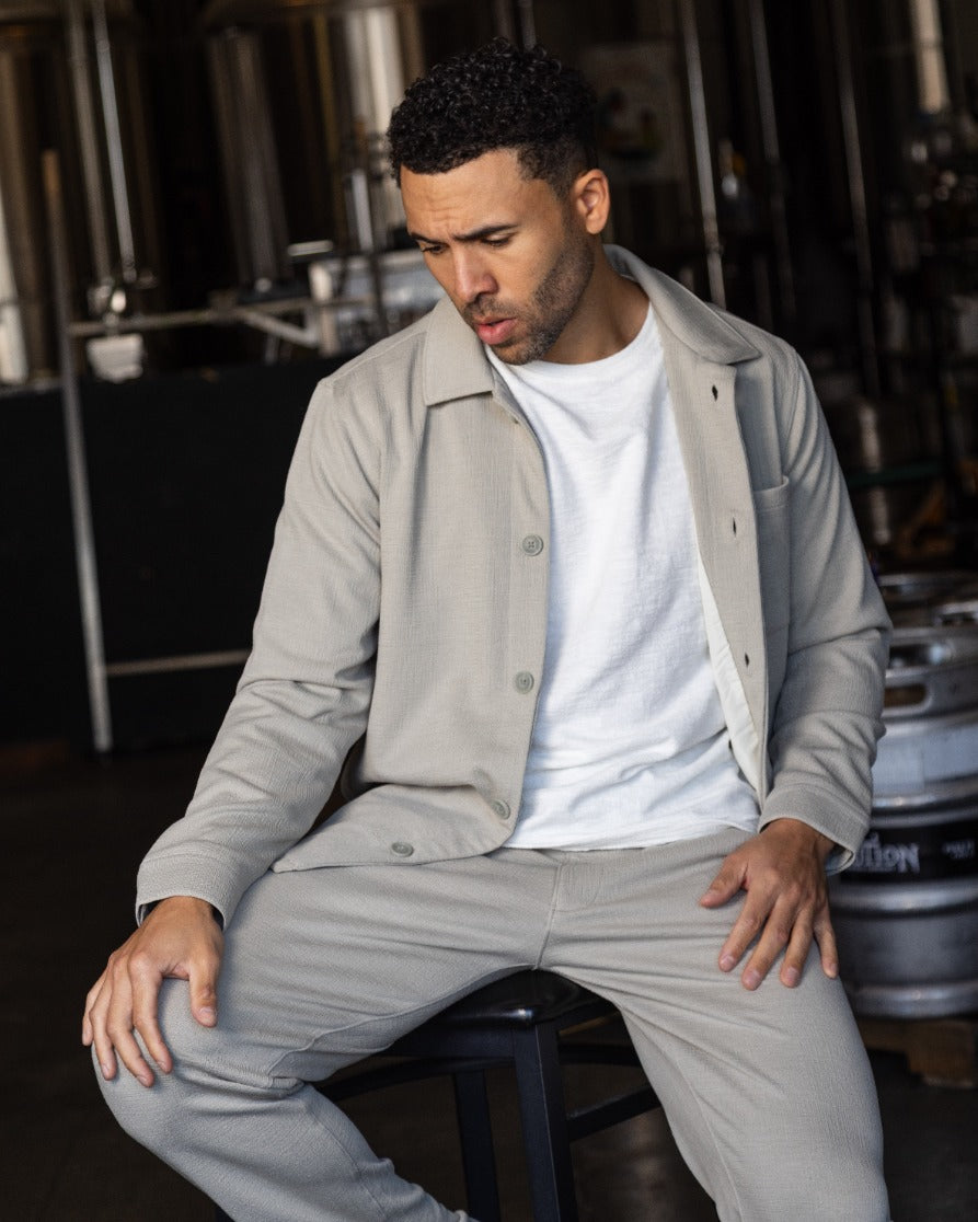Light gray button-front jacket, open collar, long sleeves with button cuffs