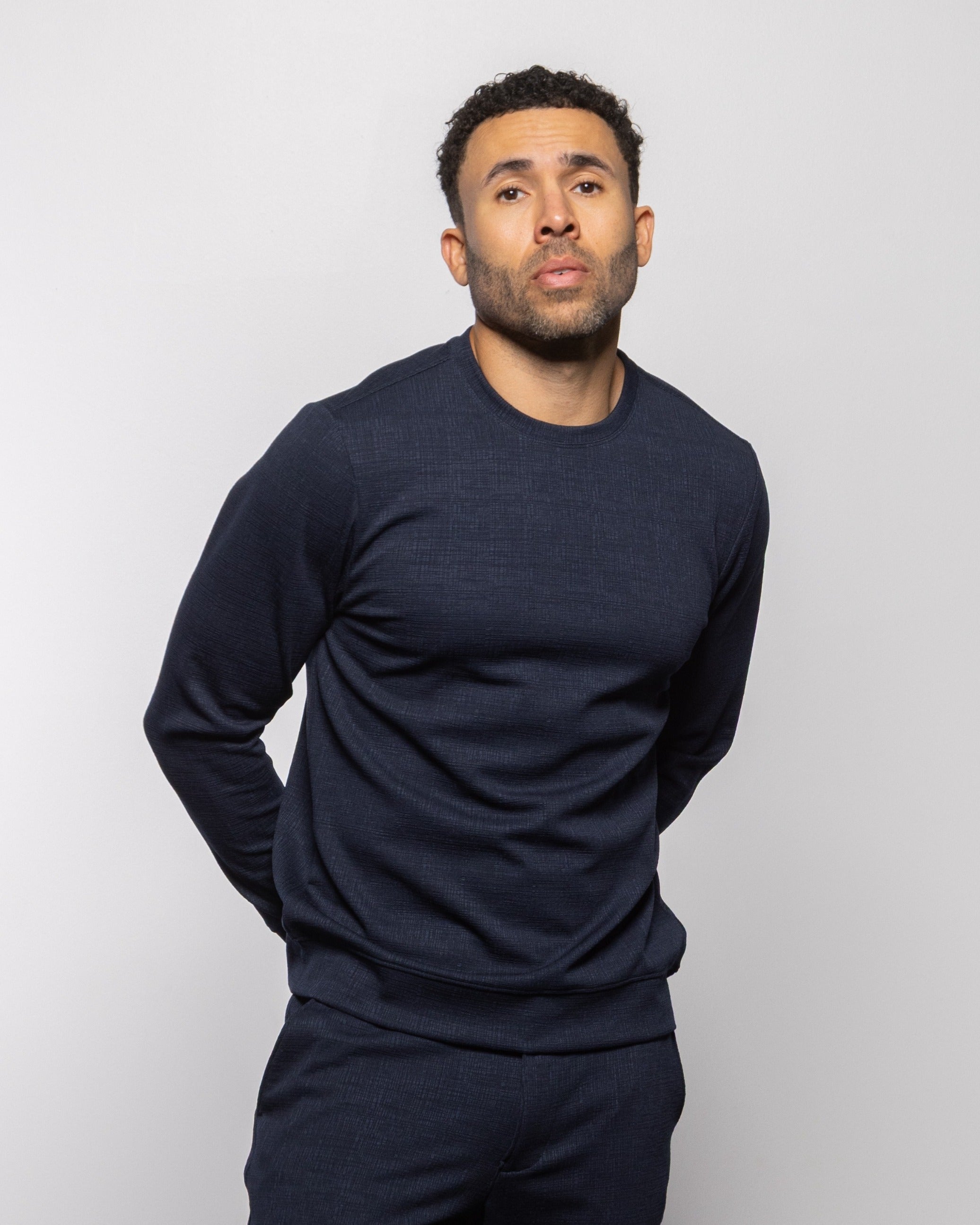 Men's crewneck sweater in dark indigo with long sleeves and ribbed cuffs, full view