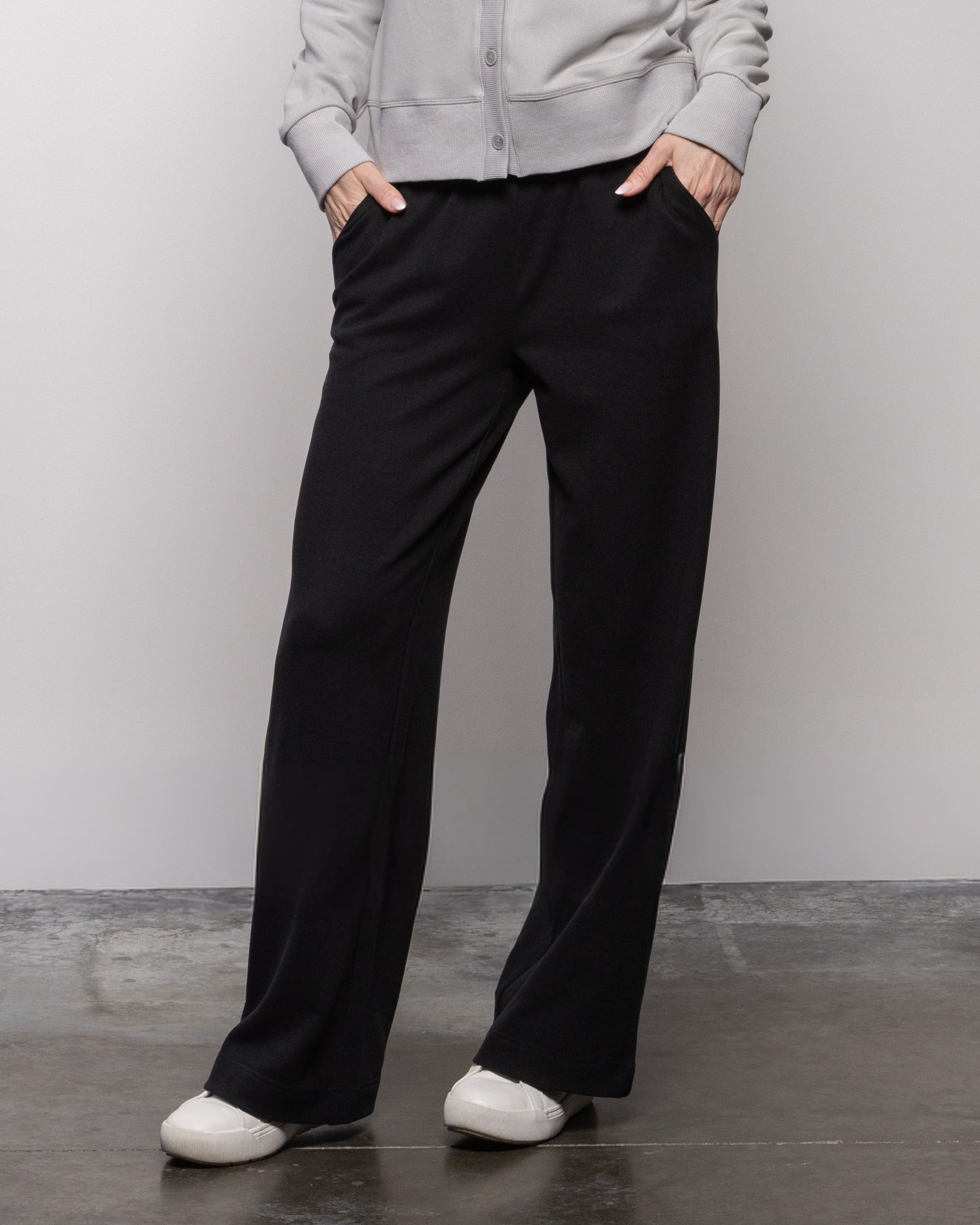 Jet black wide-leg pants with front crease, roomy straight legs and side pockets
