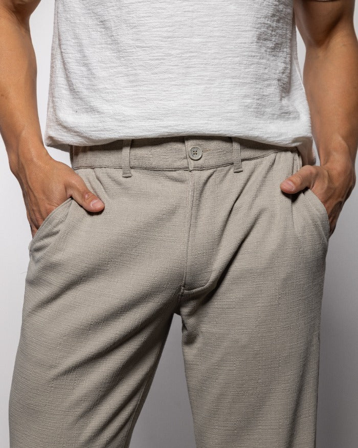 Men's quartz beach pants, close-up of button fly and waistband, slim tapered leg