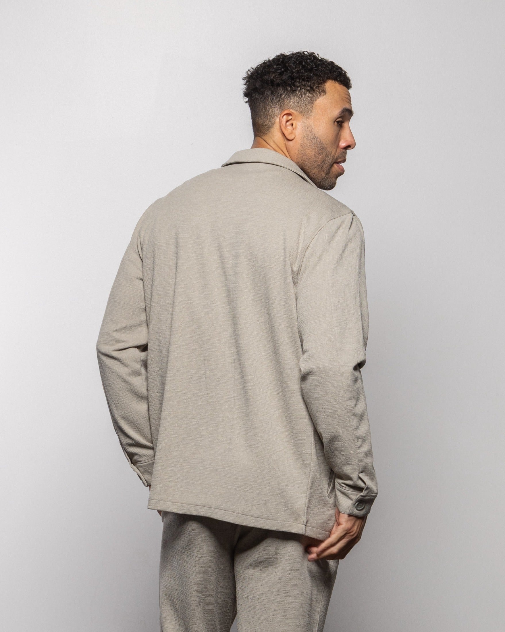Light gray jacket back view with button closure and long sleeves