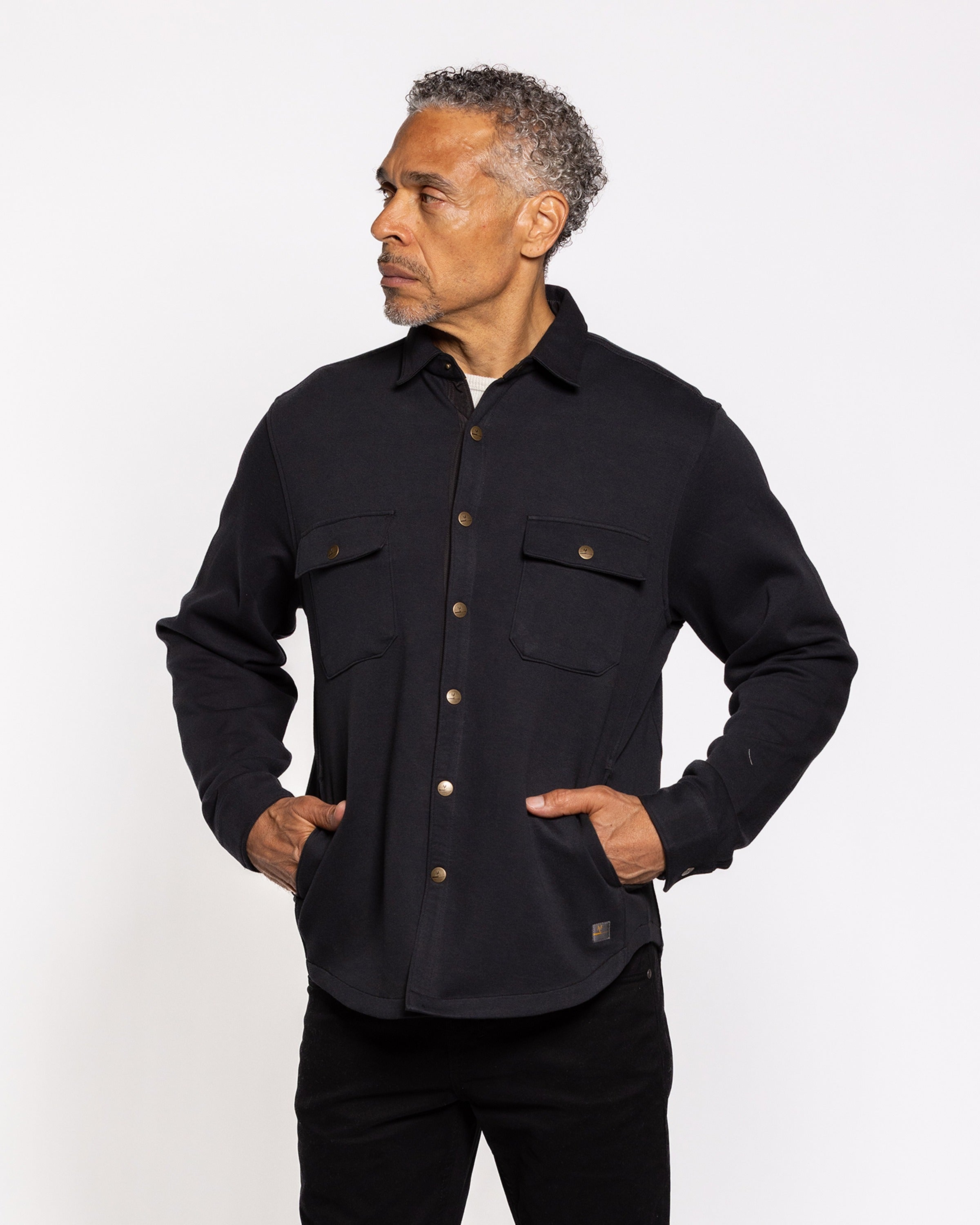 Black shirt jacket, three-button placket, chest pockets, long sleeves, profile view