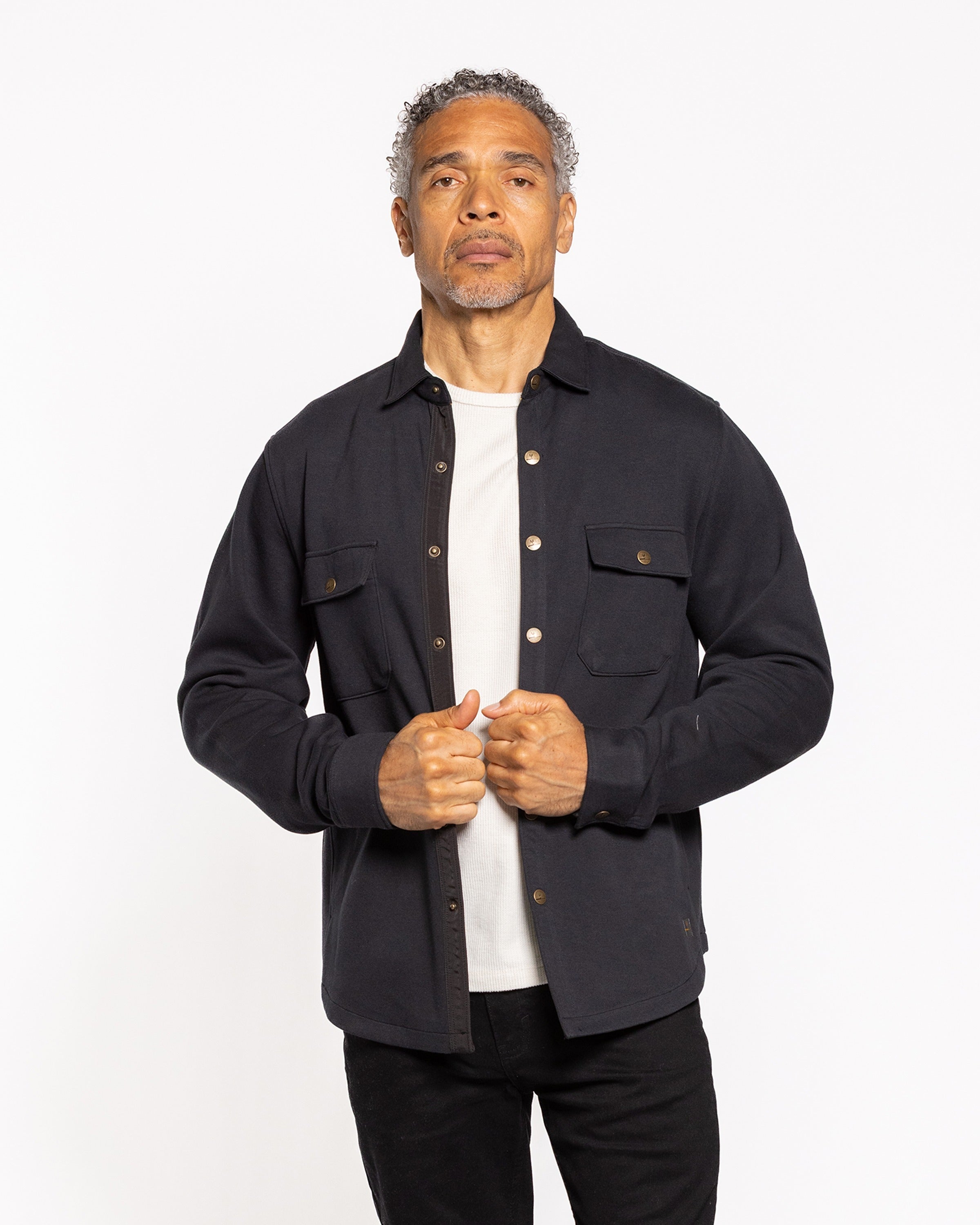 Black shirt jacket with button-front and chest pockets over white tee, front view