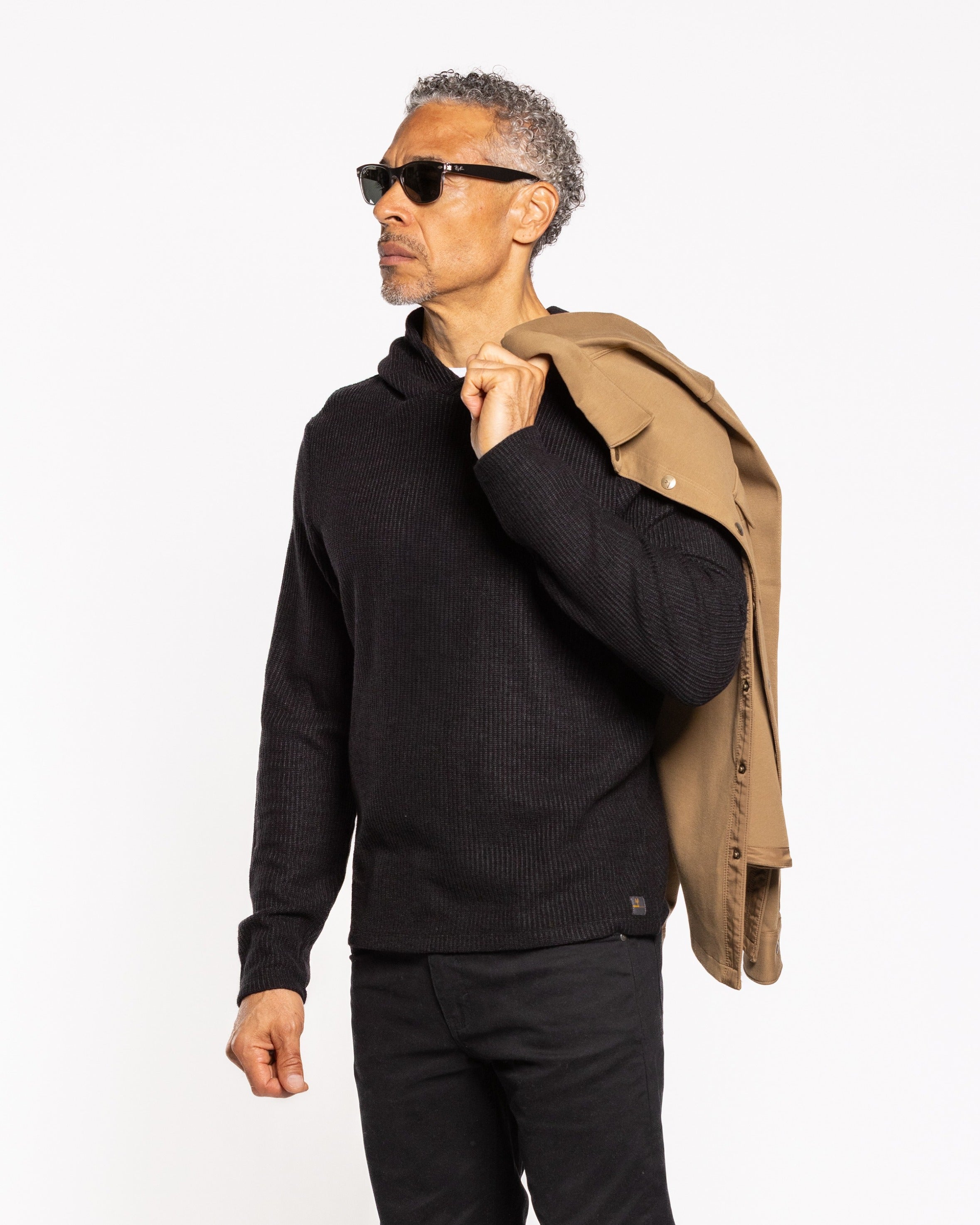 Jet black hoody, textured knit look, drawstring hood, ribbed cuffs; side view.
