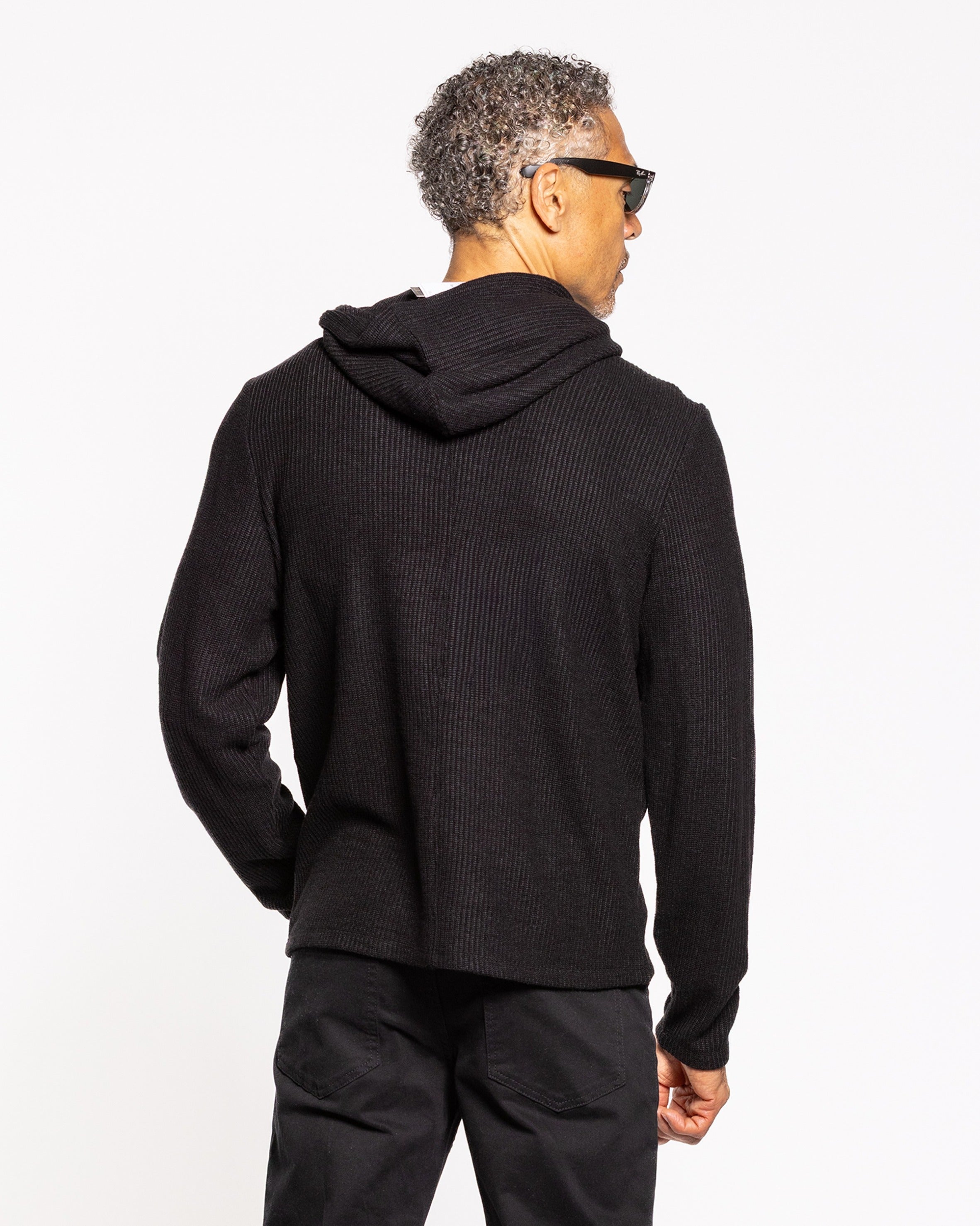 Jet black hoody back view with hood and ribbed cuffs, no logo visible.