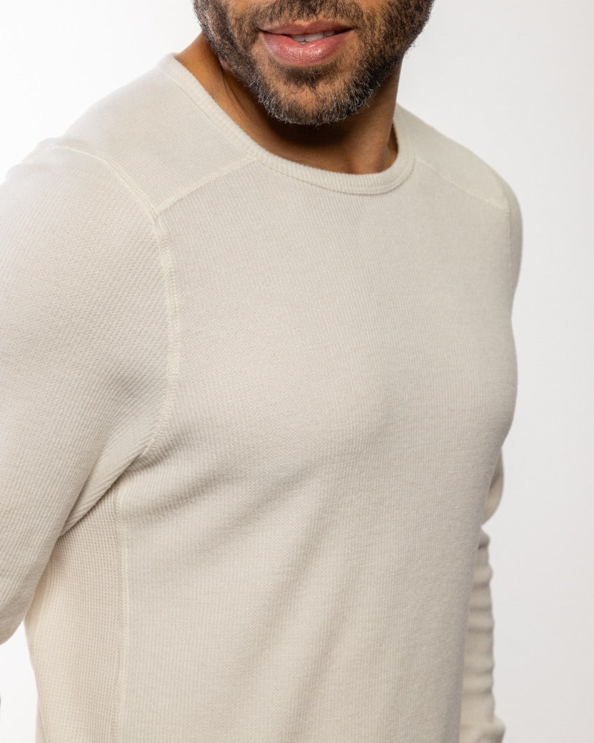 Light off-white crewneck knit fabric close-up with fine texture